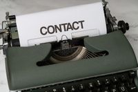 Schreibmaschine und weißes Blatt mit Aufschrift Contact